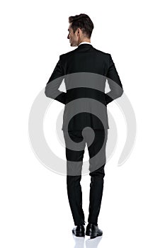 Back view of young elegant man in tuxedo