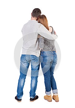 Back view of young embracing couple (man and woman) hug and look