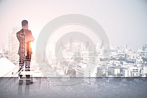 Back view of young european man standing on abstract rooftop white city background with mock up place. Success and leadership