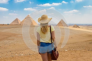 Back view of the young female watching the Great Pyramids of Giza in Egypt