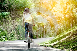 Back view of young girl riding bicycle in the garden