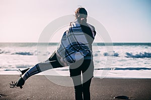 Back view of young lonely woman enjoying ocean.