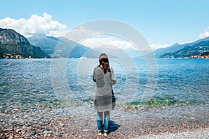 Back view of young lonely woman relaxing on Como Lake in Italy