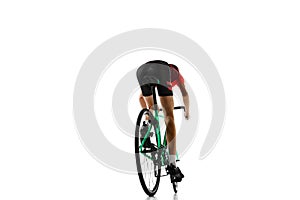 Back view. Young man, cyclist in sportswear and helmet riding bicycle, training isolated over white studio background.