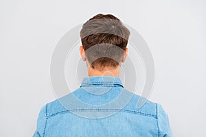 Back view of young man isolated on gray background