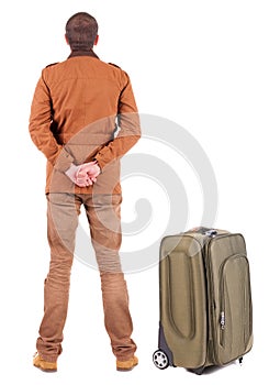 Back view of young man traveling with suitcas.