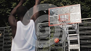 Back View of Young Musculy Afro American Guy in White Singlet Throwing Ball into a Basket and Scoring, Training at