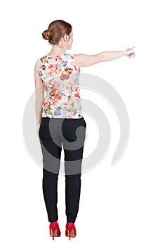 Back view of young redhead business woman pointing at wal