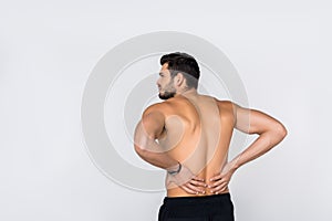 back view of young shirtless man with back pain