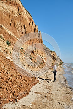 Back view of a young woman and backpack walks alone