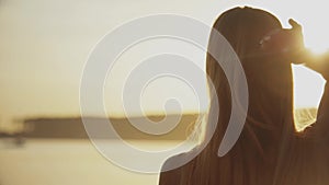 Back view of young woman at beach relaxing by the sea in summer. Evening relax.