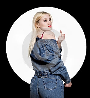 Back view of young woman in denim jaket and jeans show middle finger, you off sign on white background. indecent