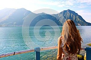 Back view young woman with dress looking at beautiful lake landscape in front of her. Copy space.