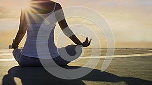Back view young woman hand meditation lotus pose in sunlight mood  on the rooftop building and evening sky scene