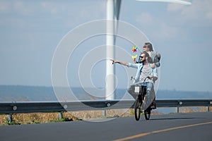 young woman riding a bicycle with her boyfriend on the road