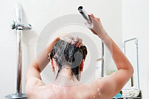 Back view of young woman washing her hair