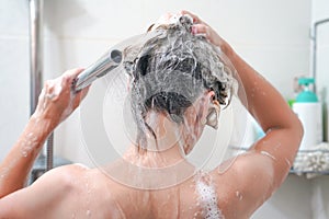 Back view of young woman washing her hair