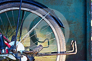 The back wheel of the old bicycle with shadow on metal panel an