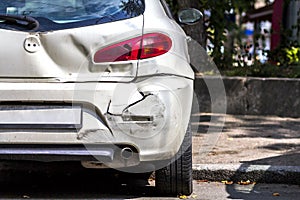 Back of white car damaged by accident on the road