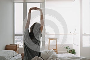 Back of woman just wake up and looking at the view in the morning.