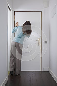 Back woman looking at peephole