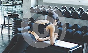 Back Woman workout in fitness gym and doing some push ups on Fitness chair