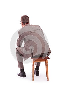 Back of a young business man sitting on a chair