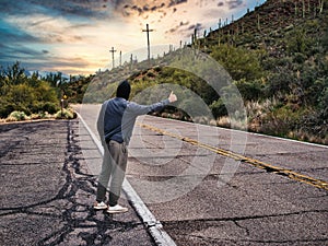 Back of young man, hitchhiker waiting on roadside