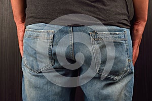 Back of young man wearing grey blank t-shirt, standing in a stud