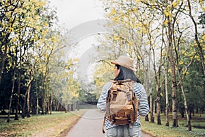 Back of young traveler woman backpacker looking forward at fores