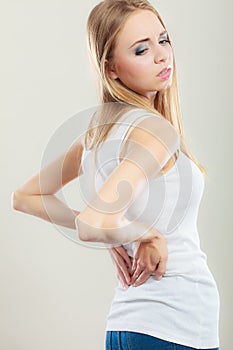 Backache. Young woman suffering from back pain