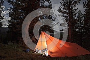 Backcountry camping in a lit tarp tent photo