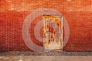 Backdoor, old weathered door and brick wall