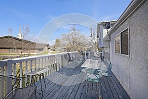 Backdoor veranda of a house with a view of a lawn and nearby building and road