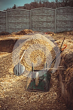 Backfilling of the excavation under the foundation slab. Construction, dolomite, shovels and wheelbarrow.