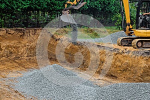 Backfilling trench for the stones gravel at construction site in excavator backfill of foundation