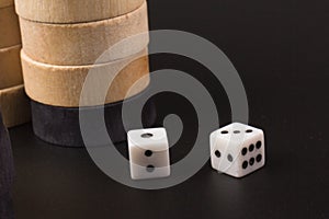 Backgammon. Board game. White cubes and chips on a blackboard.  Dice on backgammon board game. Playing leisure games photo