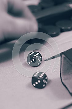 Backgammon set,  player moving piece,  on a cloth and leather board.