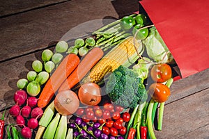 Backgroud of fresh food tasty and healthy many vegetables come out of paper shopping bag on the wooden table