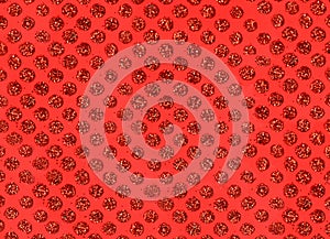 Backgroun pattern of sparkly red circles on a red background.