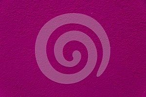 solid magenta textured stucco wall background close up