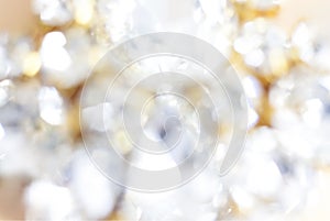 Background of abstract glittering lights. Blurred crystal beads for the background. Silver and gold. de-focus.