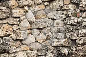 Background of the antique wall of the old stone. Weathered surface. Stones of different sizes and shapes