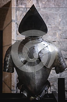 Background with armour of the medieval knight. Metal protection of the soldier. Steel Plate. Rivets and engraving, dark light