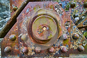 Background asset industry rusty metal bolt with peeling corroded rivets with oil spill colors