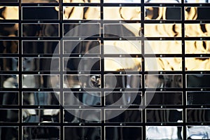 Background or backdrop of polished metal mirrored rectangles, imitating brickwork. Photo. Daylight