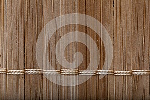Background bamboo sticks with thread uniting. texture of straw mat brown weave rug