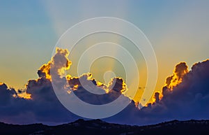 Background from a beautiful sunset with clouds and sunlights over mountanous coast