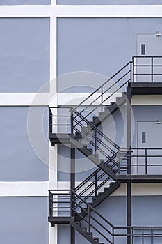 Background of black steel fire escape on gray and white building wall in under construction