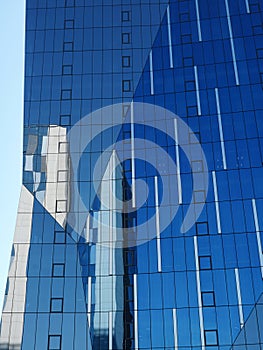 Background of blue glass wall of office building reflecting another office building in Bucharest